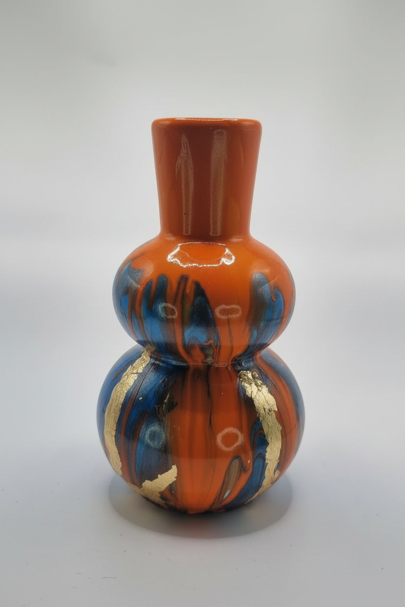 Decorative ceramic item with orange, blue, and gold patterns on a white background